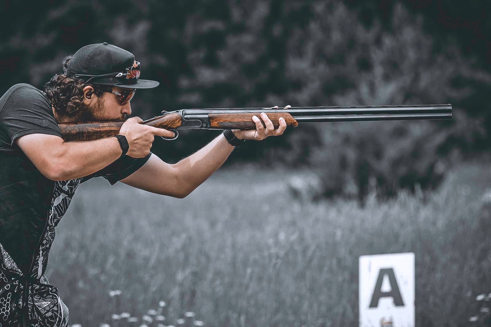 David holding a shotgun in a focused competition stance.