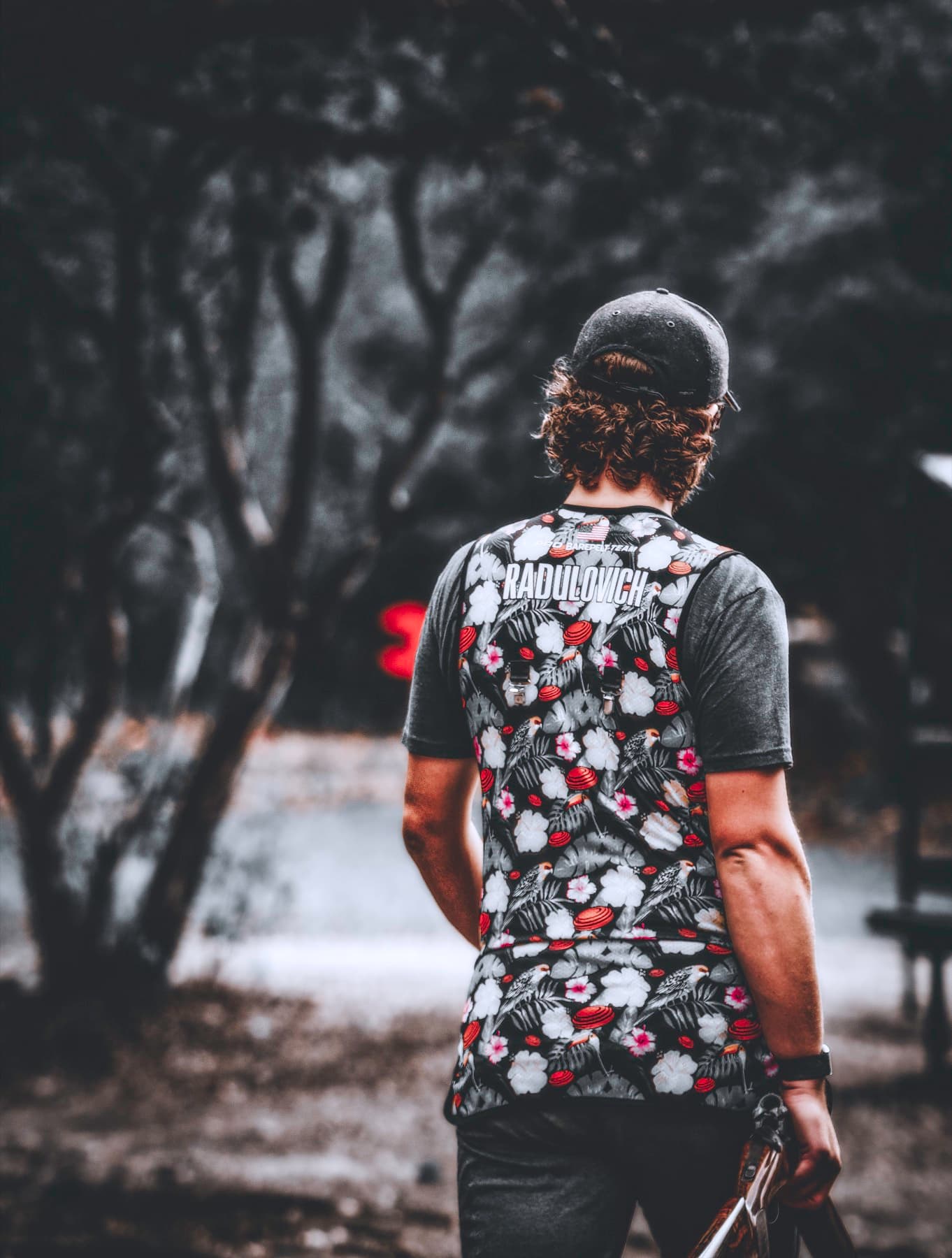 David seen from behind with dark trees in the distance.