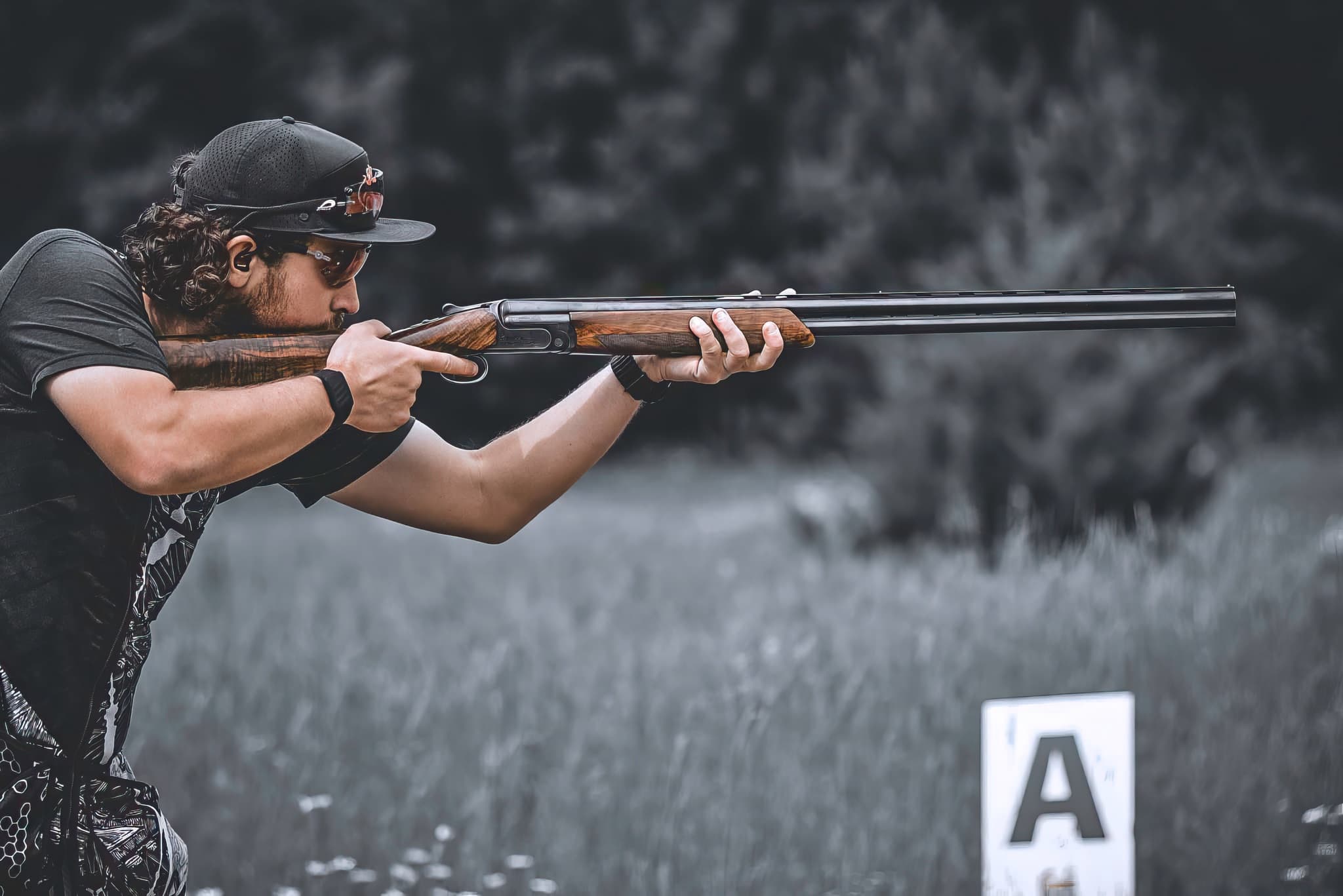 A shooter reading a target line with a shotgun shouldered