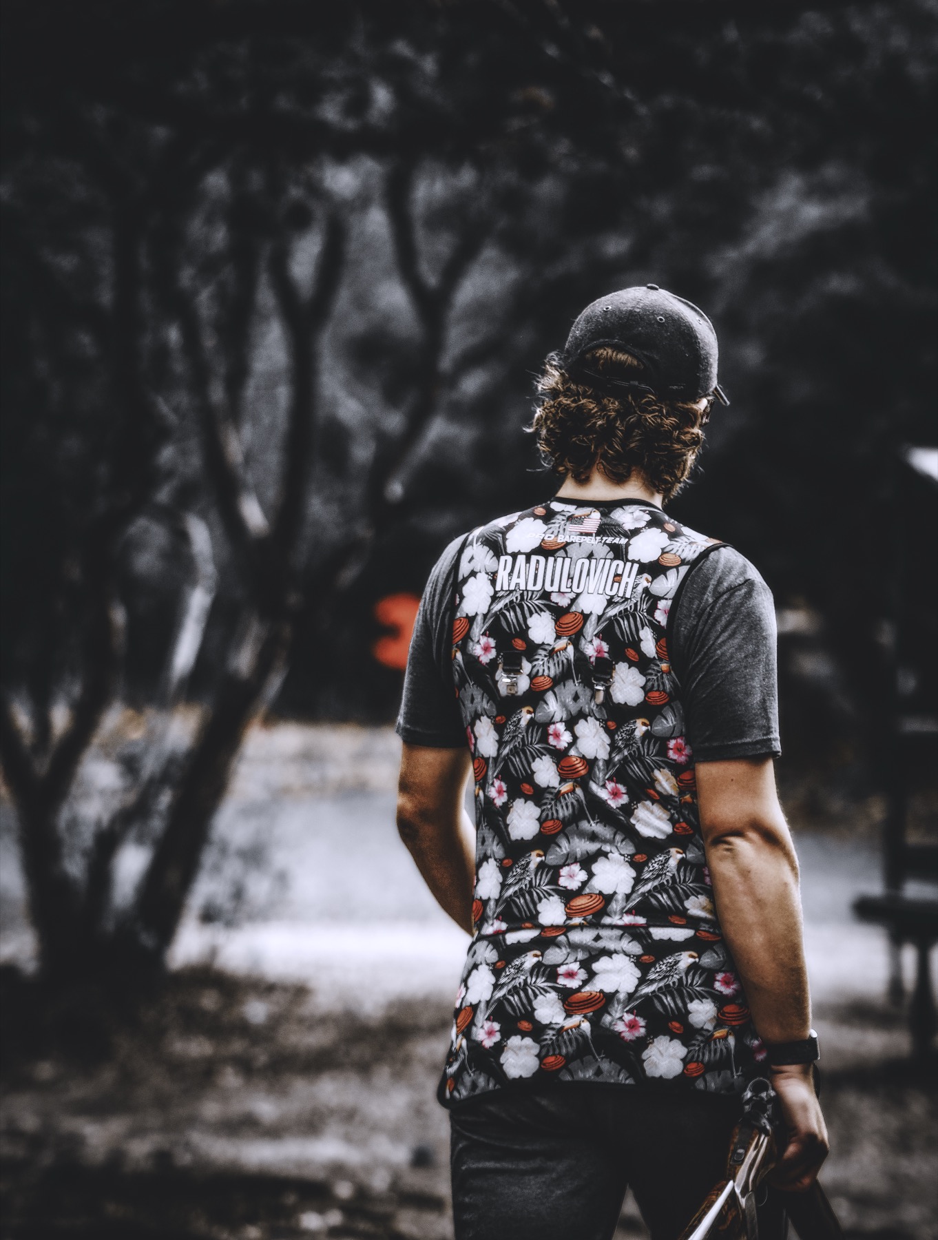 David seen from behind with dark trees in the distance.